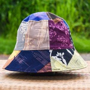 以下が含まれることがあります： 青、紫、茶色、黄色など、さまざまな色とパターンが組み合わされたパッチワークのバケットハットです。