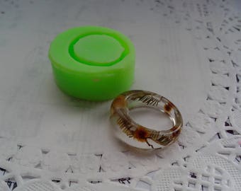 May include: A green silicone ring mould and a clear resin ring with dried flowers inside.