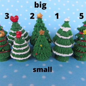 Puede incluir: Conjunto de diez árboles de Navidad en miniatura, cinco son más grandes y cinco son más pequeños. Los árboles más grandes están decorados con rayas rojas y blancas, estrellas doradas y una luna creciente. Los árboles más pequeños están decorados con glaseado blanco, corazones rojos y estrellas doradas. Los árboles están dispuestos en dos filas, etiquetadas como "grande" y "pequeño".
