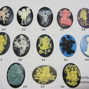 Puede incluir: Treinta y seis colgantes de camafeo de forma ovalada, en negro, blanco, azul y amarillo. Los camafeos presentan diversos diseños de hadas, ángeles y motivos florales.
