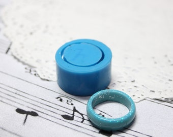 May include: Two blue silicone moulds for making jewellery. The larger mould is a ring shape, and the smaller mould is a round shape.
