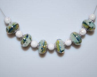 Necklace with handcrafted beads in spun glass with a torch mounted on cable.