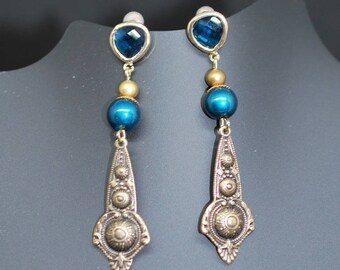 Boucles d'oreille d'inspiration antique avec perle bleue.