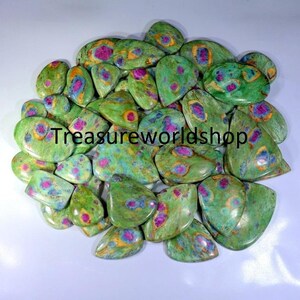 Könnte beinhalten: Eine Sammlung von grünen, rosa und gelben Rubin-Zoisit-Cabochons. Die Steine sind alle tropfenförmig und haben verschiedene Muster und Farben.