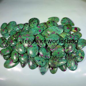Pode incluir: Um grande monte de gemas de zoisita rubi verde e rosa, também conhecidas como rubi em zoisita, em forma de lágrima.