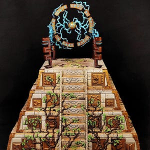 Könnte beinhalten: Eine Miniatur-Pyramidenstruktur aus Stein mit einer zentralen Treppe, braunen, mit Symbolen verzierten Paneelen und grünen Ranken, die an der Außenseite emporwachsen. Oben umgibt ein Ring mit blauen Blitzen eine goldene Kugel.