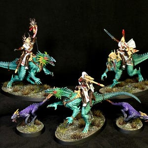 Pode incluir: Três figuras em miniatura montadas em criaturas reptilianas verde-azuladas com caudas longas e duas criaturas reptilianas roxas menores. Os cavaleiros usam armaduras brancas e marrons com capacetes altos, carregando lanças e espadas em bases.