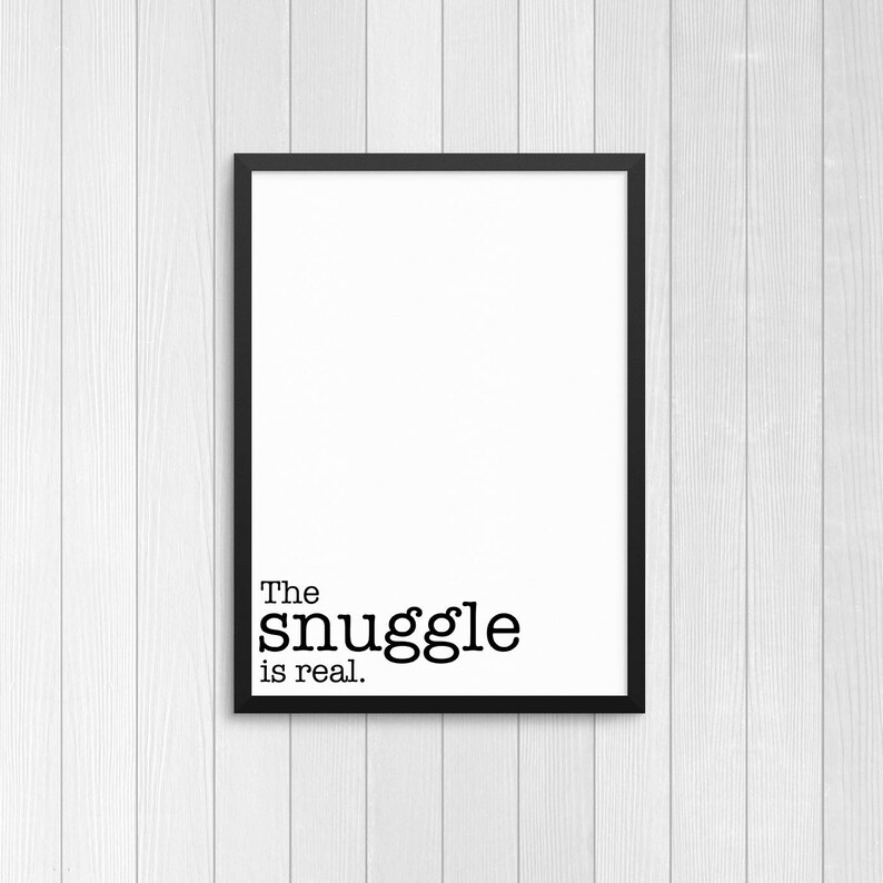 May include: Black framed print with white background and the text "The snuggle is real."