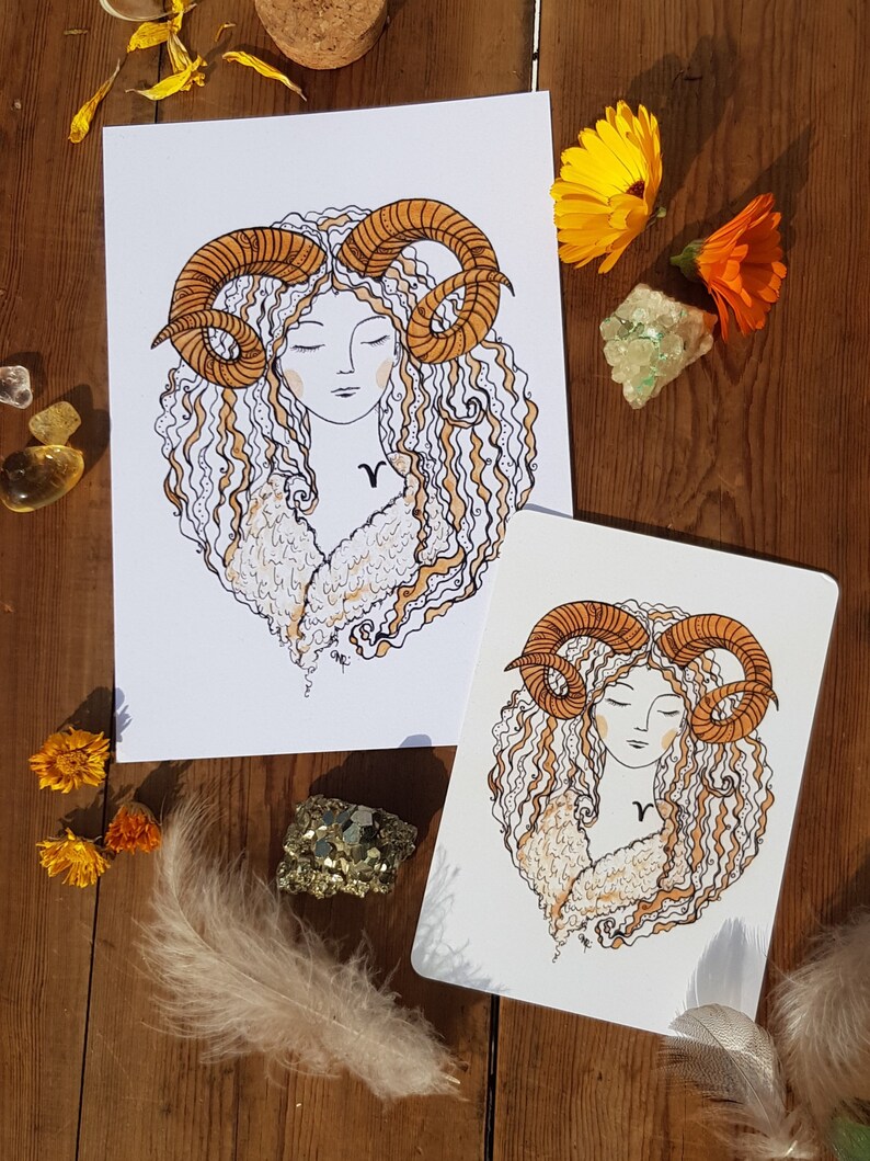 Puede incluir: Dos impresiones de arte imprimibles que presentan una ilustraci&oacute;n estilizada de una mujer con cabello rizado y cuernos de carnero. La mujer lleva un abrigo de piel blanco y tiene un s&iacute;mbolo del zod&iacute;aco en el pecho. Las impresiones est&aacute;n en papel blanco con un fondo blanco.