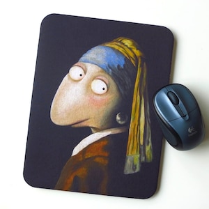 Könnte beinhalten: Ein Mauspad mit einem Cartoon-Porträt einer Person mit großen Augen und einem Perlenohrring. Der Hintergrund ist dunkel und die Person trägt ein braunes Hemd.
