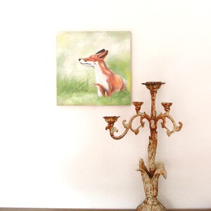 May include: A painting of a red fox with its eyes closed, sitting in a grassy field. The fox is painted in a realistic style with soft, muted colors.