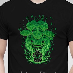 May include: Black t-shirt with a green graphic print of a cartoon character surrounded by flames and leaves. The text "etsy.com/shop/TechraNova" is printed on the bottom of the shirt.