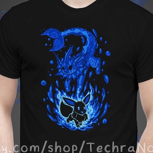 May include: Black t-shirt featuring a blue graphic of a Pokemon character, Vaporeon, and a smaller Pokemon character, Eevee, surrounded by blue flames. The text "etsy.com/shop/TechraNova" is printed on the bottom of the shirt.