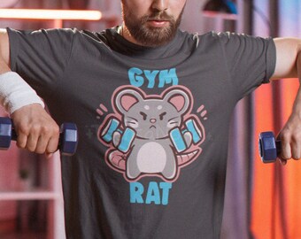 Könnte beinhalten: Ein dunkelgraues T-Shirt mit den Worten "GYM RAT" und einer Cartoon-Maus, die Gewichte hebt. Die Person auf dem Bild trägt ein schwarzes Stirnband und Handgelenkbänder und hebt zwei blaue Kurzhanteln.