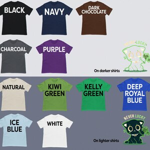 May include: A graphic design of a cartoon cat with a clover in its paw. The cat is wearing a black collar with a white bone. The text "Never Lucky" is above the cat. The design is shown on a variety of t-shirt colors, including black, navy, dark chocolate, charcoal, purple, natural, kiwi green, kelly green, deep royal blue, ice blue, and white.