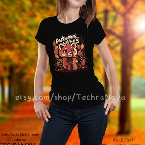 May include: Black t-shirt with a red panda illustration holding a cup of coffee and surrounded by autumn leaves. The text "Autumn Vibes" is above the panda.