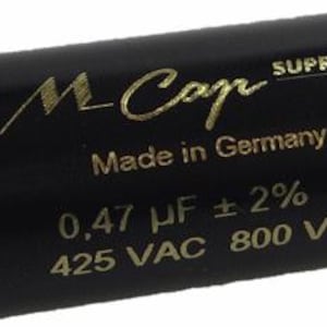 May include: A black cylindrical capacitor with gold lettering. The text reads "M-Cap Supreme Made in Germany 0,47 µF ± 2% VD 425 VAC 800 VDC".