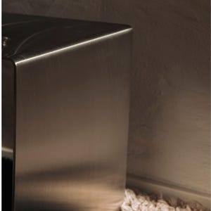 May include: Close-up of a brushed stainless steel surface. The surface is smooth and reflective, with a slight sheen.