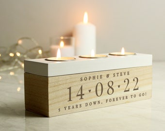May include: A wooden candle holder with three candle slots. The holder is engraved with the text "Sophie & Steve 14.08.22 5 years down, forever to go!"