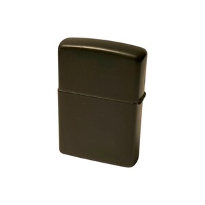 Puede incluir: Un encendedor rectangular negro con bordes redondeados y una tapa con bisagras. El encendedor tiene un acabado mate. El dise&ntilde;o es simple y funcional. El encendedor se muestra sobre un fondo blanco.