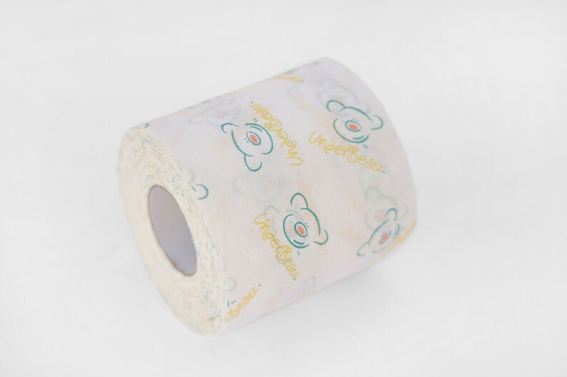 Puede incluir: Un rollo de papel higi&eacute;nico blanco con un patr&oacute;n repetido de osos verdes y el texto "UnderBears" en amarillo.