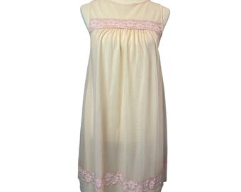 May include: A sleeveless, cream-colored nightgown with a sheer overlay. The nightgown features a pink lace trim at the neckline and hem. The fabric drapes from the shoulders to the mid-calf.