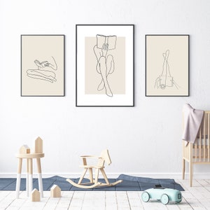 May include: Three black framed illustrations of line drawings of a person sitting and reading a book, a person sitting with legs crossed and a person with legs up in the air.