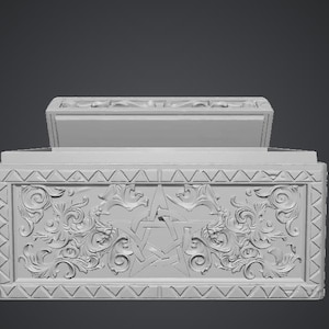 May include: A light grey rectangular box with a hinged lid. The front panel features a central pentagram symbol surrounded by intricate, symmetrical scrollwork and floral relief carvings, framed by a border of repeating triangular patterns.