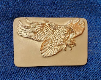 Hebilla de cinturón con águila plateada, fundida a mano en aluminio cepillado, de William Bill Hald, 2011.