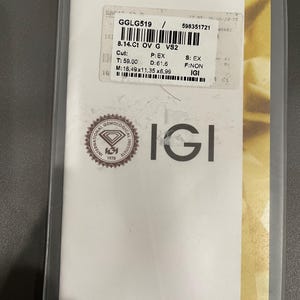 May include: A white certificate with a gold border and the text "International Gemological Institute" at the top. The certificate is for a diamond with the following information: GGLG519, 8.14 Ct, OV, G, VS2, Cut: T: 59.00, D: 61.6, M: 16.49x11.35 x6.99, P: EX, S: EX, F: NON, IGI.