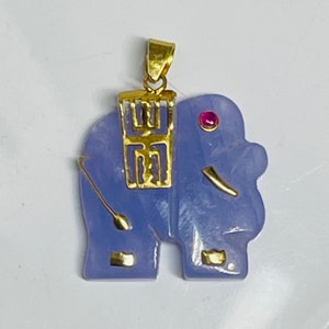 May include: A lavender jade elephant pendant with gold accents and a small red gemstone eye. The pendant features a gold charm with Chinese characters.
