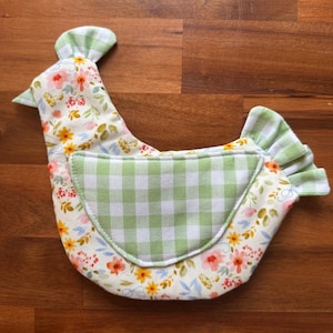 May include: A fabric chicken-shaped kitchen accessory featuring a white base with a colorful floral pattern of pink, orange, and yellow flowers. It includes a light green and white gingham check wing, tail, and comb, with a matching gingham pattern.