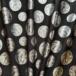 May include: Black fabric with a repeating pattern of silver disco ball designs.