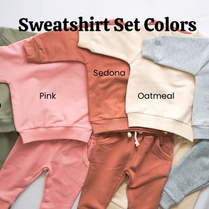 Pode incluir: Cinco conjuntos de moletom e cal&ccedil;as de moletom para beb&ecirc;s em diferentes cores. As cores s&atilde;o verde s&aacute;lvia, rosa, Sedona, aveia e cinza esportivo.
