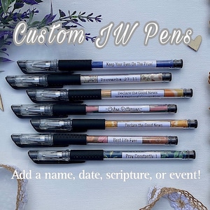 Peut inclure: Un ensemble de huit stylos noirs avec des &eacute;tiquettes personnalis&eacute;es. Les &eacute;tiquettes comprennent des citations inspirantes, des versets bibliques et des noms. Les stylos sont dispos&eacute;s en rang&eacute;e sur une surface blanche.