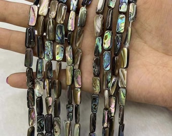 May include: A strand of iridescent abalone shell beads in a rectangular shape. The beads are a mix of brown, green, and blue colors.