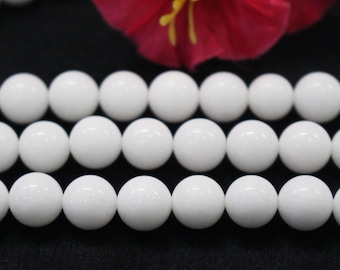 Puede incluir: Una hebra de cuentas redondas blancas, hechas de piedra natural, para la elaboración de joyas.