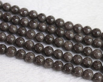 May include: A strand of dark gray gemstone beads. The beads are round and have a smooth, polished finish.