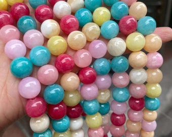 Puede incluir: Una hebra de cuentas redondas de colores hechas de piedra natural. Las cuentas son en tonos de rosa, amarillo, azul y rojo.