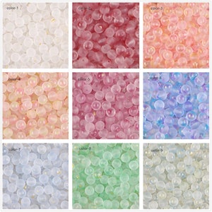 May include: Nine different colors of glass beads with a frosted finish and gold flecks. The beads are round and have a slightly irregular shape.