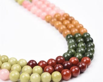Puede incluir: Primer plano de varios hilos de cuentas de piedras preciosas de colores. Las cuentas son redondas y vienen en varios colores, incluyendo verde, rosa, marrón y rojo. Las cuentas están ensartadas, creando un patrón visualmente atractivo.