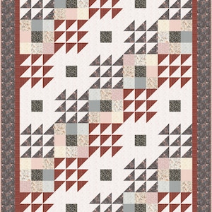 May include: A handmade quilt featuring a cream-coloured backdrop with a repeating pattern of triangles and squares in shades of brown, grey, and pink. The quilt has a floral border and a dark brown binding.