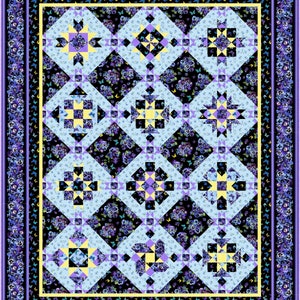 May include: A quilt block pattern with a blue, yellow, and purple color scheme. The quilt block is set against a background of a floral print with purple flowers and green leaves.