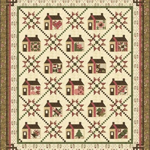 May include: A quilt with a pattern of houses and stars in shades of brown, green, pink, and white. The houses are surrounded by a border of floral print fabric.