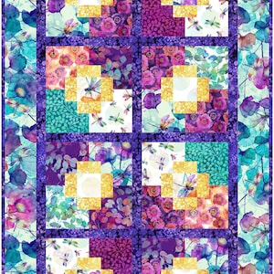 May include: A quilt block with a patchwork design featuring a variety of floral patterns in shades of purple, pink, yellow, and blue. The block is made up of nine smaller squares, each with a different pattern. The background of the block is a light blue with a watercolour effect.