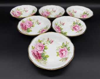 May include: Set of six white porcelain bowls with gold trim and floral designs. The bowls feature pink roses and green leaves.