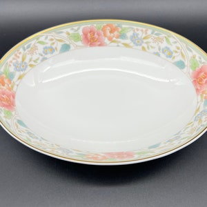 May include: A white oval serving bowl with a floral design in shades of pink, green, and blue. The bowl has a gold rim.
