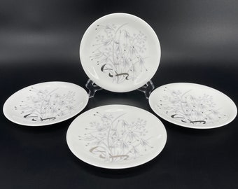 May include: Set of four white ceramic plates with a silver floral design. The plates have a simple, elegant design and are perfect for everyday use.