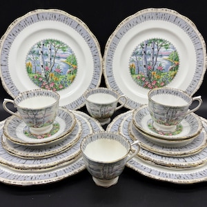 May include: A set of vintage bone china teacups and saucers with a birch tree design. The cups and saucers feature a delicate floral pattern and a gray and white birch tree design. The set includes two teacups, two saucers, two teacups, two saucers, and two larger plates.