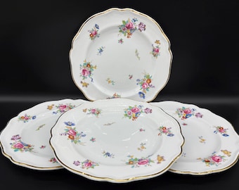 May include: Four white ceramic plates with a gold rim and a floral pattern in shades of pink, blue, and green.